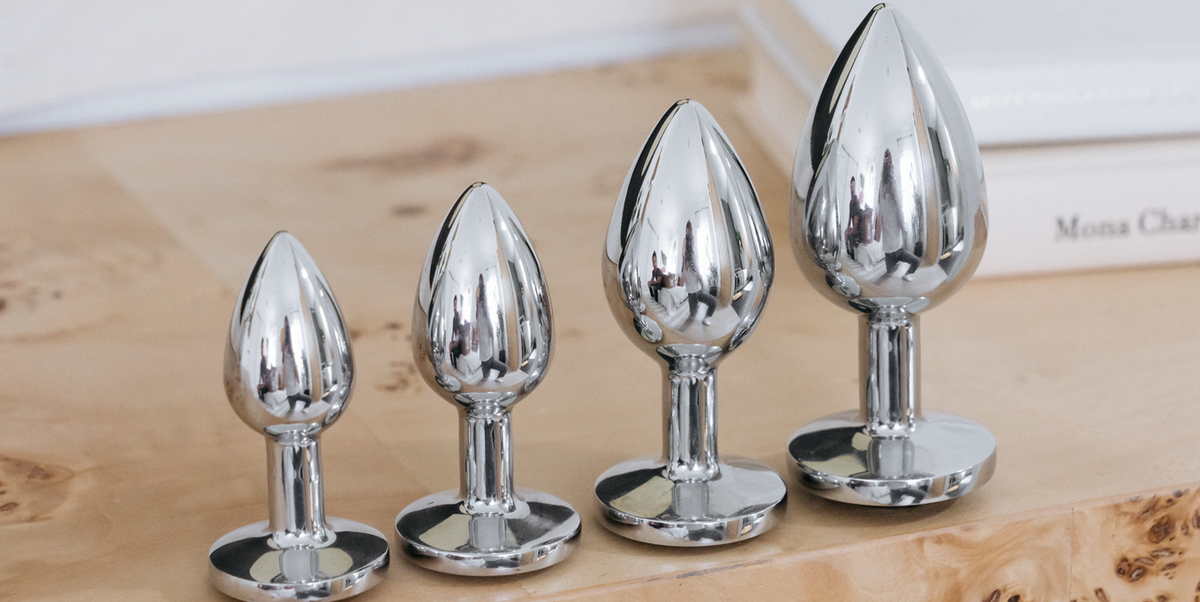 Four metal butt plugs in increasing sizes, each with a wide base